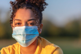AmeriCorps worker in a yellow shirt with a surgical mask on. 