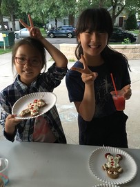 Two youth decorating gingerbread cookies