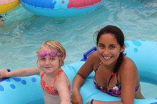 Adult and youth on a tube in the lazy river. 