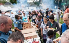Police serving food to community members at a Safe Summer Nights outdoor event. 