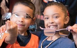 Two smiling youth holding up glasses.