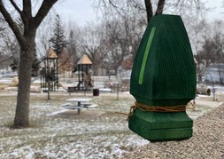 Small, wooden evergreen tree near a playground.