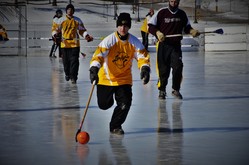 Adult playing broomball on ice in the winter
