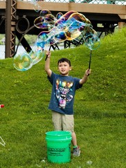 Kid playing with oversized bubbles