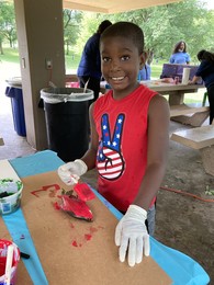 Kid painting fish at Summer Rec Check