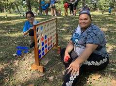 Rec Check kid and Rec Leader playing oversized Connect Four game in the park