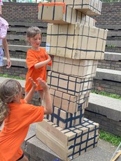 Two youth building cardboard block tower at Amazing Race event