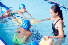 Swimming lesson instructor and three youth in a pool