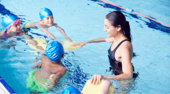 Swimming lesson instructor and three youth in a pool