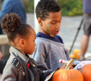 two kids looking at pumpkins