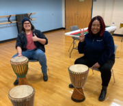 Two adults at drumming class 
