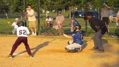 Baseball players and umpire standing at home base ready for the pitch