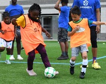 Youth playing soccer on a turf field 