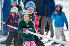 Ski instructor going up tow rope with youth student