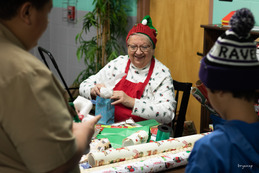 Volunteer wrapping presents at Santa's Workshop event