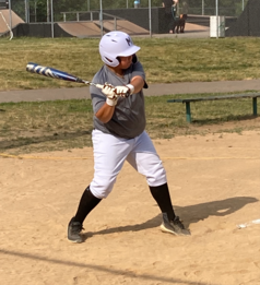 Baseball player at home base swinging a bat