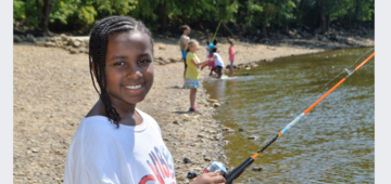 Youth with a fishing rod at the river
