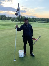 Golf Course Park Worker standing with golf hole flag
