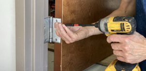 Person drilling a door hinge