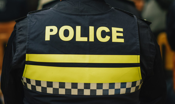 the back of a police vest with the words POLICE in yellow. 