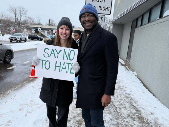 CM Coleman holding a sign that reads "Say NO to Hate" at a gathering to support Muslim community members. 