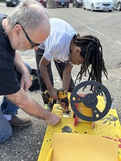 Adult volunteer helping youth build Soap Box Derby