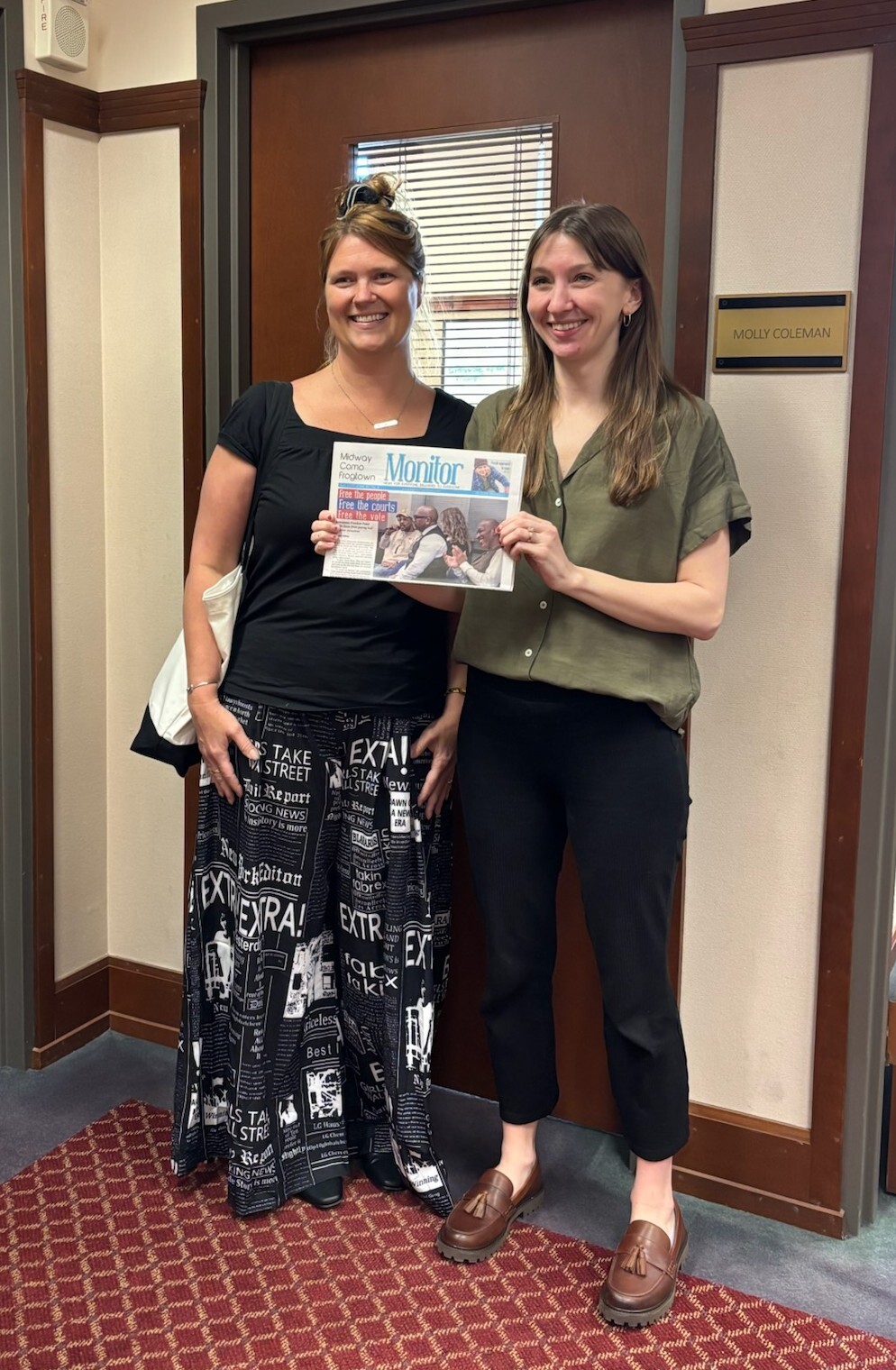CM Coleman standing next to Tesha Christensen, the owner of the Midway Como Frogtown Monitor, holding a copy of the Monitor.