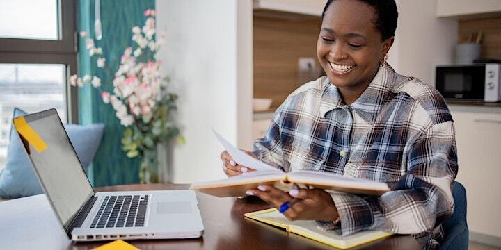 Businesswoman flips through notebooks while smiling