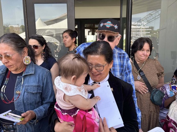 Hanging out with a little one during the Grand Opening of the Waḳaƞ Ṭípi Center