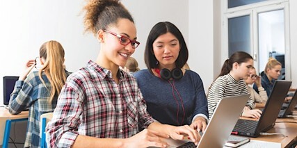 Women working at computer together