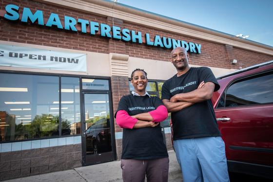 Employees posing and smiling outside place of business
