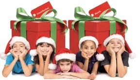 Photo of children in festive Christmas clothes posing in front of presents