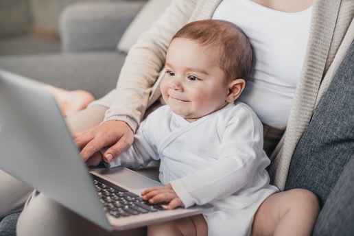 Photo of a baby sitting in front of a computer.