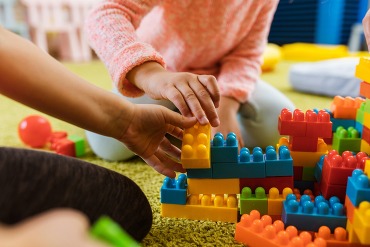 young children's hands playing with blocks