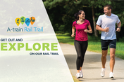 Couple running on A-train Rail Trail. Text reads: Get out and explore our rail trail