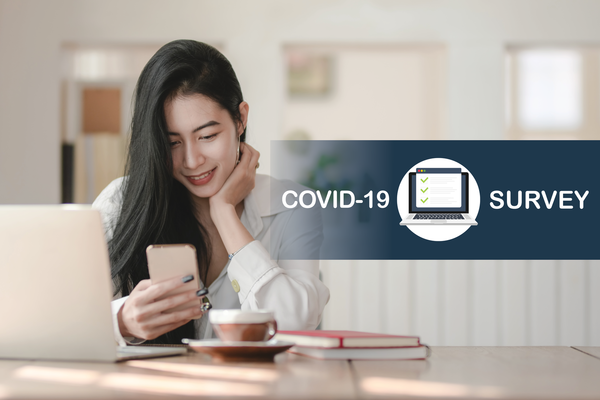 Woman sitting at a desk on her phone. Headline text: COVID-19 Survey