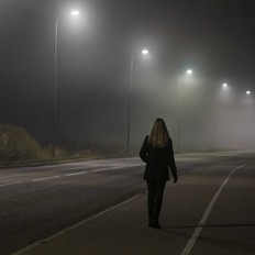 Image of woman walking alone at night.