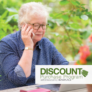 Retired woman on a laptop and a cellphone in her yard and Discount Purchase Program administered by Beneplace