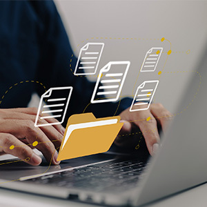 folder and file icons hovering over laptop with person typing on keyboard