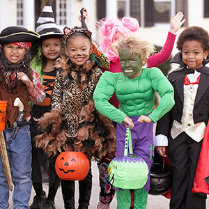 Group of six children in Halloween costumes posing for a picture