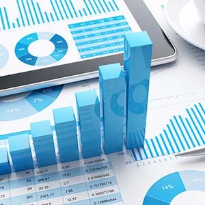 Financial documents with graphs and charts on the paper. A 3D positive graph sits on the papers.