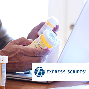 Person holding prescription pill bottle and laptop with express scripts logo overlay