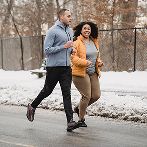 two people jogging in winter snow outside