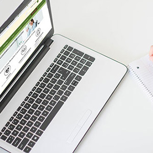 BCCG homepage screen on laptop with journal on desk