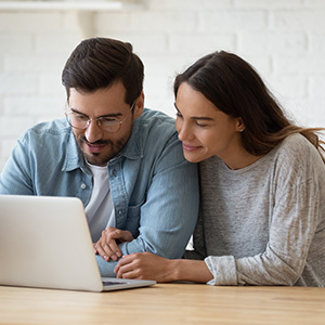 couple in kitchen looking at laptop