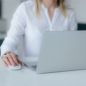 Woman working on laptop with mouse