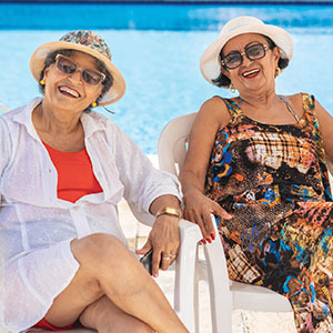 Senior women poolside wearing a hat and sunglasses