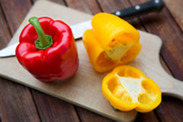 two peppers on wooden table with knife