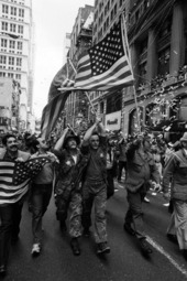 Vietnam War veterans march up Broadway, showered with tickertape and carrying American flags.