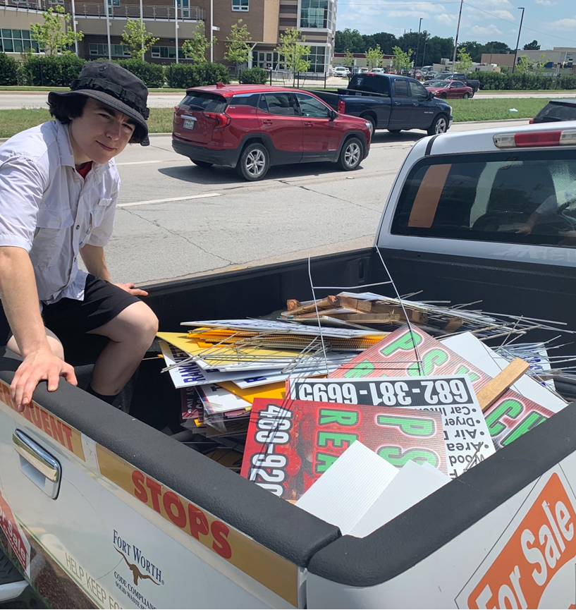 Code Rangers volunteer Lauren Deodati posing with a truck full of bandit signs